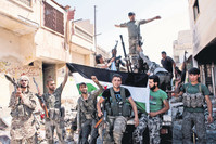 Members of the Free Syrian Army fighting against the Assad regime under harsh conditions show their strength in captured areas.