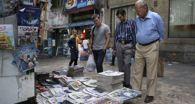 People read front pages of Iranian newspapers at a news stand in the Tajrish Sq. northern Tehran, Iran.