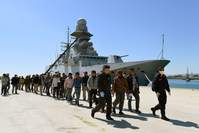In this file picture rescued migrants walk along the quayside after disembarking from the Italian Navy vessel Bettica as they arrive in the Sicilian harbour of Augusta on April 22, 2015. (AFP Photo)