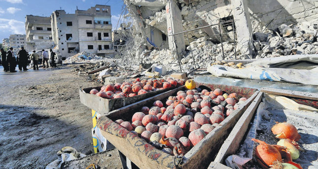 Products are covered in dust as people inspect a site claimed to be hit by airstrikes of the Russian air force on a busy marketplace in the town of Ariha, in Idlib province, Syria.