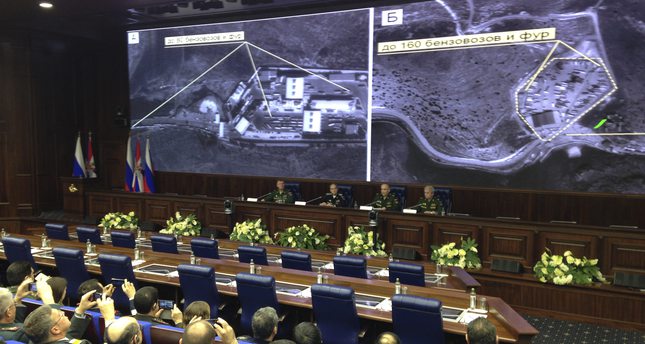 Russian top military officials speak to the media in front of an aerial images they say are oil trucks near Turkey’s border with Syria displayed by the Russian Defense Ministry, Dec. 2, 2015. (AP Photo)