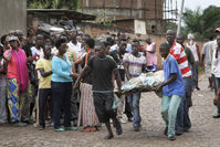 Men carry away a dead body in the Nyakabiga neighborhood of Bujumbura, Burundi, Saturday, Dec. 12, 2015 (AP Photo)