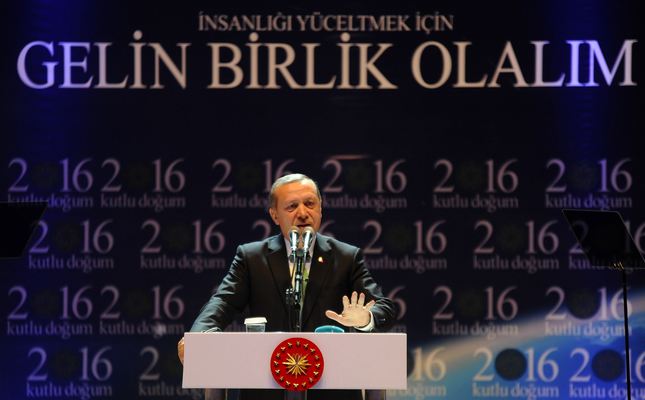 President Erdoğan reacts as he gives a speech in front of a poster with the slogan that reads Lets join hands to dignify the humanity in Istanbul on Sunday.