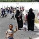 Syrian refugees in Turkish camp watch news of home