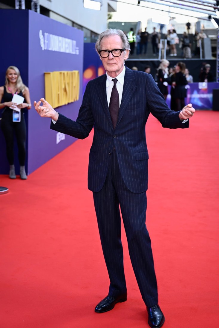 Bill Nighy, olabildiğince klasik omuzlara sahip bir takım elbise içinde